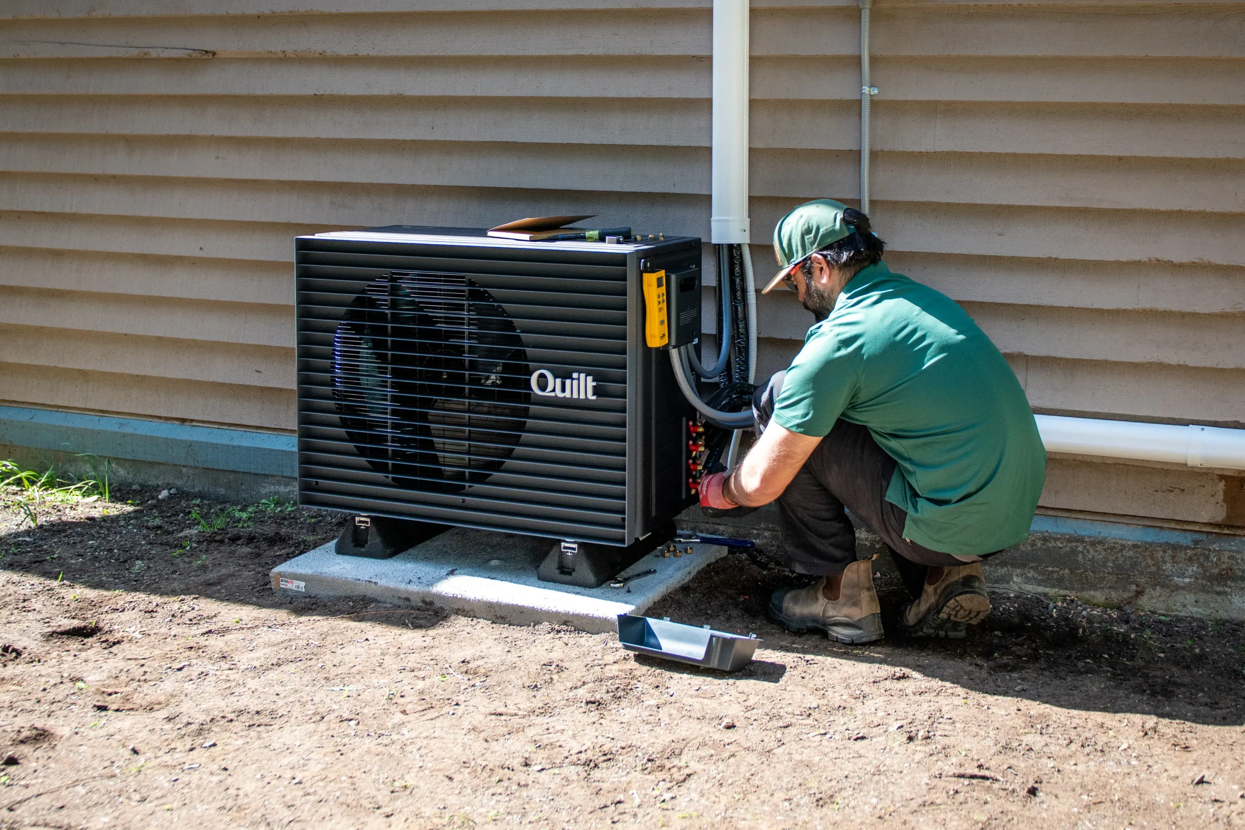 Sasquatch technician performing a winter-prep visit on a Moovair heat pump system